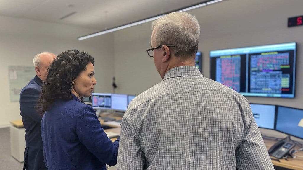 Engineers reviewing data on screens in a control room
