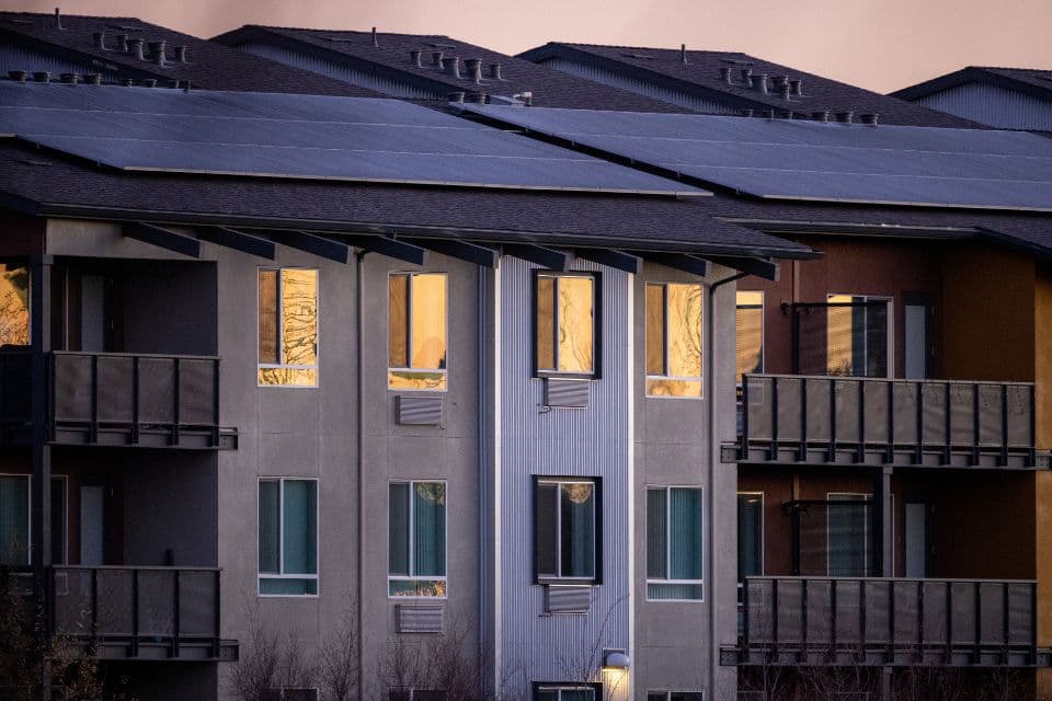 Apartment building with solar panels on the roof at dusk